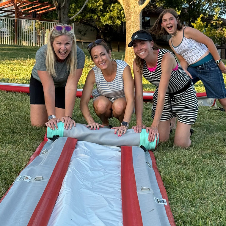 A group of friends setting up a Swole Slide together